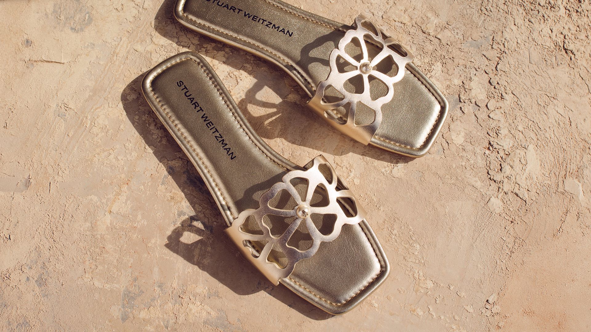 Stuart Weitzman Jasmine slide sandals in gold metallic leather with floral cutout upper 